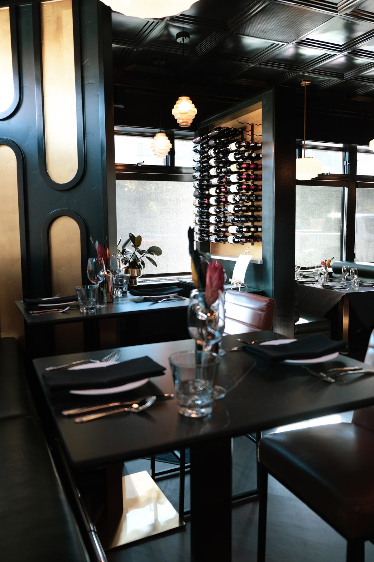 The Olive & May dining room, with its wine wall and green banquettes