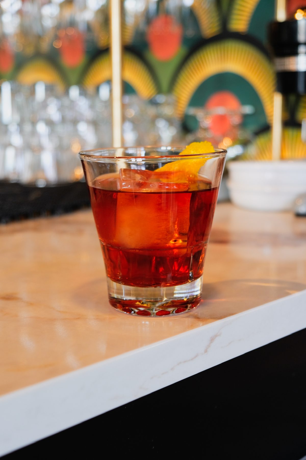 Negroni on the bar against Olive & May's deco wallpaper